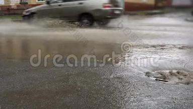 雨水落在道路上，流经下水道排水沟。 汽车在洪水中行驶.